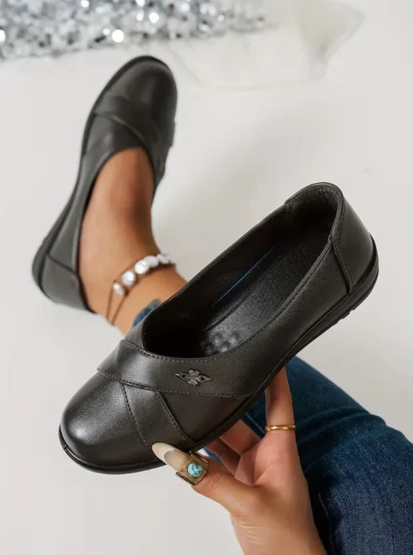 Women’s Leather-Look Supportive Slip-On Shoes With Metal Emblem