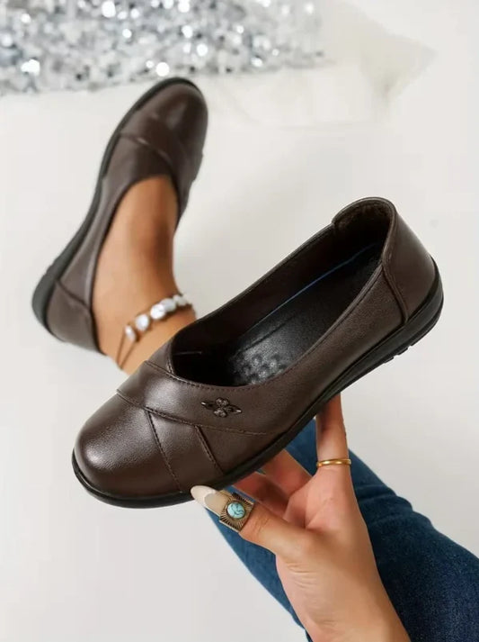 Women’s Leather-Look Supportive Slip-On Shoes With Metal Emblem