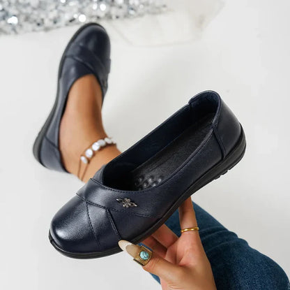 Women’s Leather-Look Supportive Slip-On Shoes With Metal Emblem